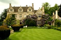 a large house with lots of trees and bushes around it's front lawn area