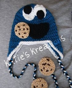 a crocheted hat with cookie cookies attached to the front and side, on top of a gray t - shirt