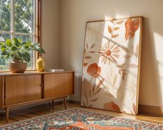 a living room with a rug, vase and painting on the wall next to a window