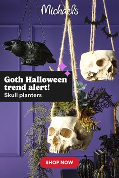 halloween decorations hanging from the ceiling in front of a purple wall with bats and skulls