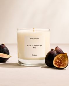 a candle with figs next to it on a table