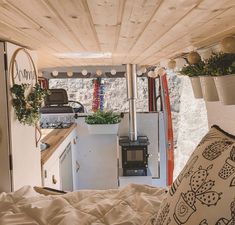 the interior of a small camper is decorated with potted plants and decor items