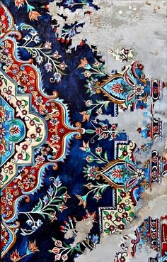 an intricately designed rug with blue and red colors