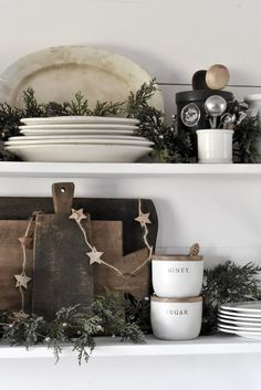 the shelves are decorated with dishes, plates and greenery for holiday decorating purposes