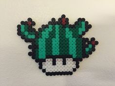 the pixel art is made to look like an image of a green cactus with red eyes