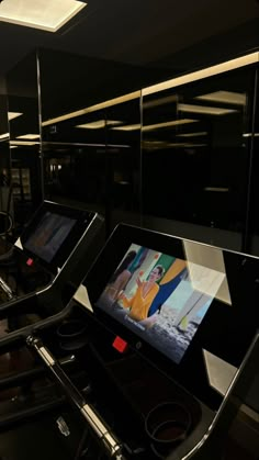 there are two screens on the treadmills in this gym area, one is displaying an image of a woman's face