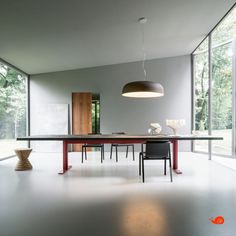 a dining room table and chairs in front of large windows