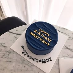 a blue birthday cake sitting on top of a table