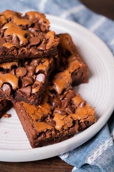 some brownies are on a white plate with chocolate chips