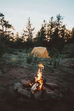 a campfire with a tent in the background