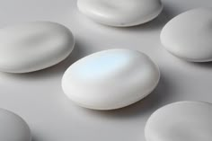 four white rocks sitting on top of a table next to each other in the shape of an egg