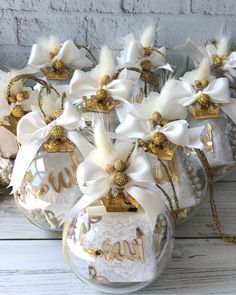 some glass ornaments with white flowers and gold letters