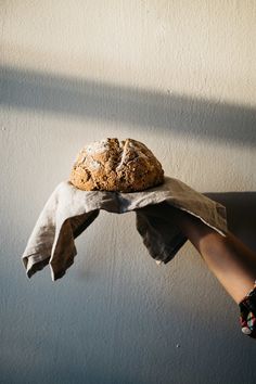 a person holding a loaf of bread in their hand