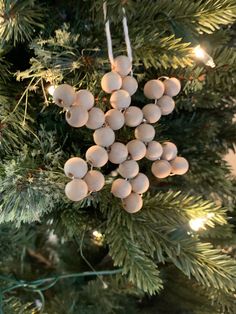 an ornament hanging from the christmas tree with white balls and lights on it