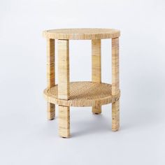 a round table made out of bamboo with one shelf on the bottom and two shelves at the top