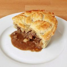 a piece of meat pie on a plate with gravy