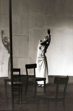 a woman reaching up to catch a frisbee in front of two empty chairs