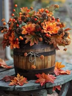 a wooden barrel filled with lots of autumn leaves