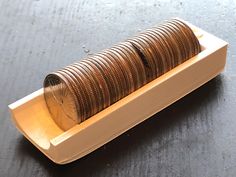 a stack of coins sitting on top of a white container filled with metal coils