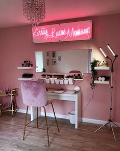 a pink chair sitting in front of a desk with a light on top of it