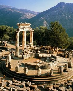 an ancient roman ruins with mountains in the background