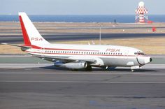 a large passenger jet sitting on top of an airport tarmac next to the ocean