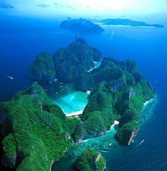 an aerial view of several small islands in the ocean with blue water and green vegetation