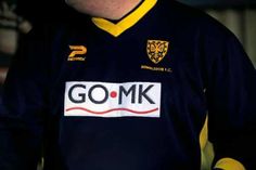 a man wearing a black and yellow uniform with the word gomk on it