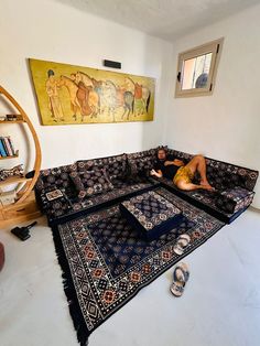 a man laying on top of a rug in a living room