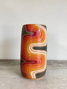 a colorful vase sitting on top of a table