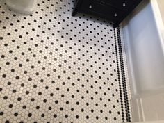 a bathroom with black and white tile flooring