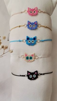 six bracelets with different designs on them sitting on top of a white cloth bag