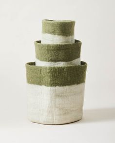 three green and white striped baskets stacked on top of each other