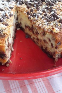 a cake with chocolate chips on top is sitting on a red plate