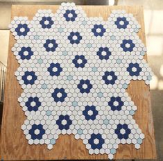 a wooden table topped with blue and white hexagonal tiles on top of it