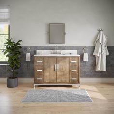 a bathroom with a sink, mirror and towel rack on the wall next to a potted plant