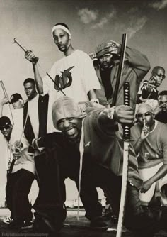 a group of men standing next to each other holding baseball bats