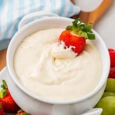 a white bowl filled with cream and strawberries