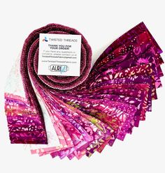 purple and pink scarves are stacked on top of each other, with a white tag that says twisted threads