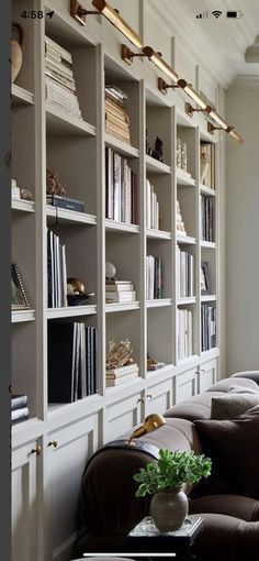 a living room filled with lots of bookshelves next to a couch and table