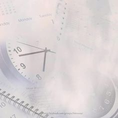 a close up of a clock with clouds in the background and words written on it