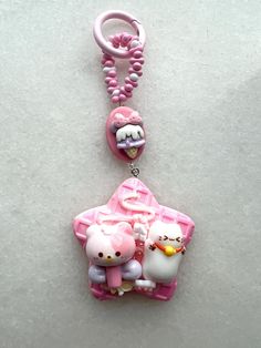 a pink key chain with hello kitty and other characters hanging from it's side