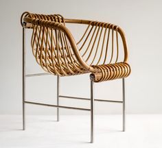 a wicker chair sitting on top of a white floor next to a metal frame