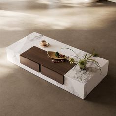 a modern coffee table with marble top and wooden drawers in an empty living room area