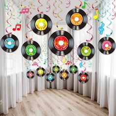 a room filled with lots of vinyl records hanging from the ceiling and streamers on the wall