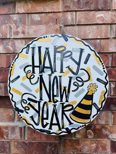 a sign that says happy new year hanging from the side of a brick building with a party hat on it