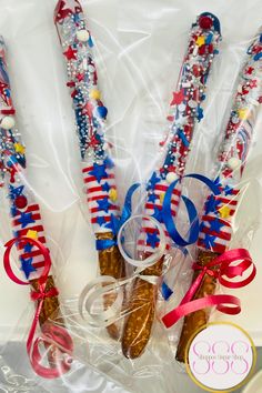 three red, white and blue strawberries wrapped in cellophane with ribbons on them