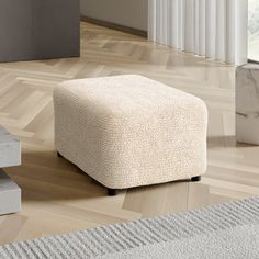 a white ottoman sitting on top of a hard wood floor