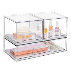 two clear acrylic boxes with different items inside them on top of each other