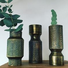 three vases with plants in them sitting on a table